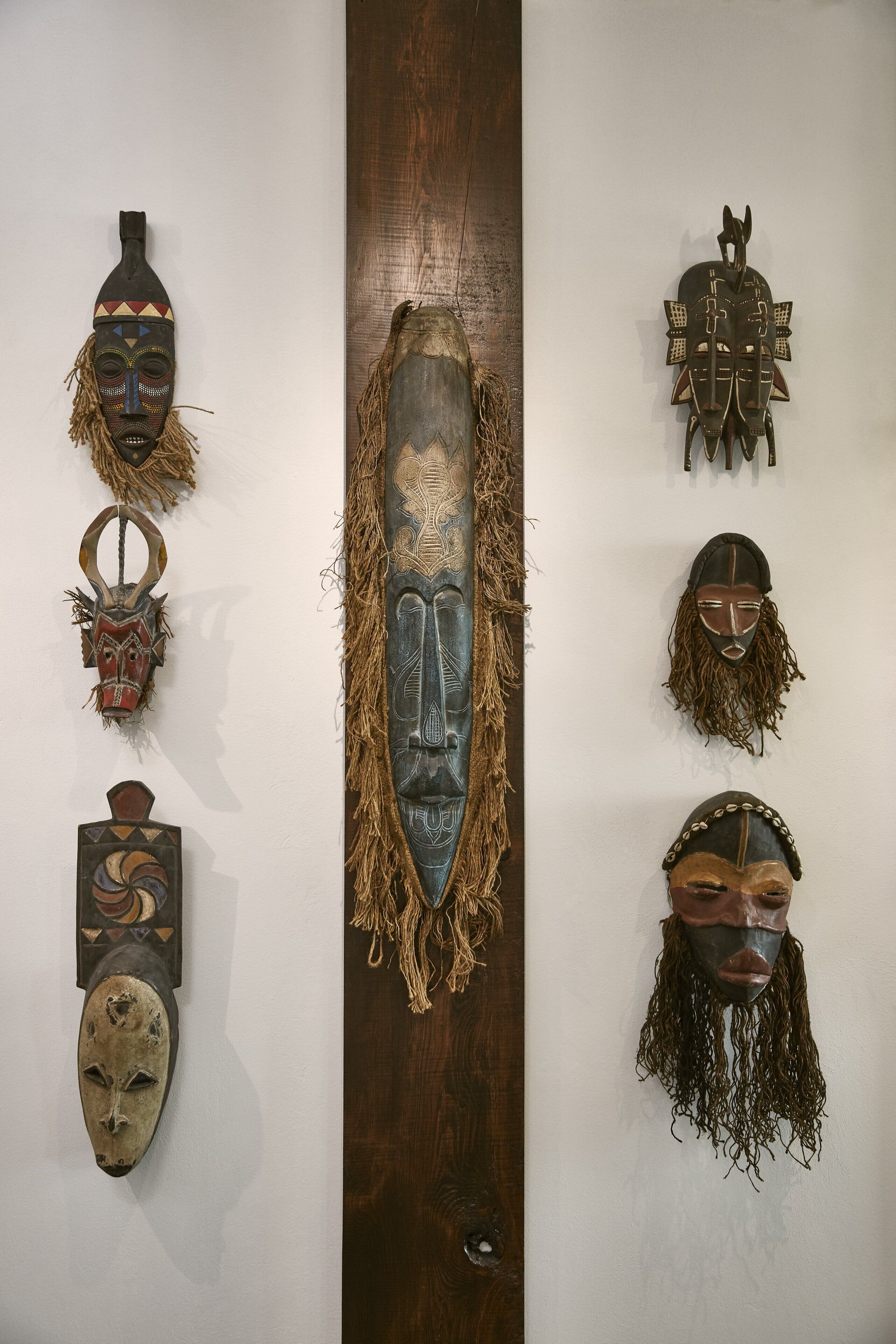 A collection of traditional masks displayed on a wall.