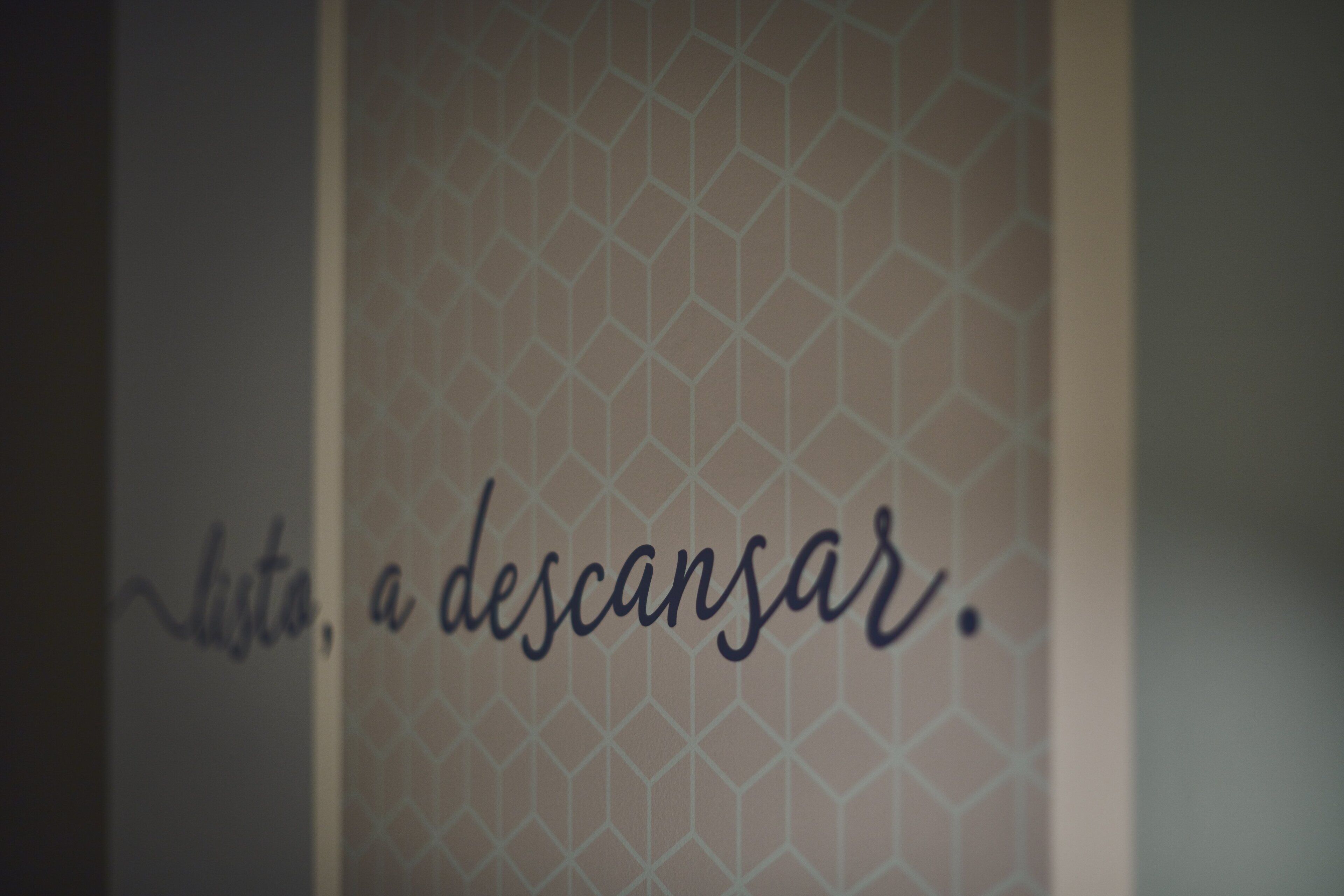 Un mur orné d’un motif géométrique sur lequel est inscrit le texte : « lista, a descansar ».