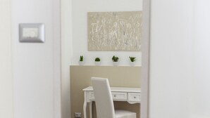 A room with a white desk, a chair, a bed with a beige blanket, and a wall-mounted air conditioner. - Domus Dams B&B (Montescaglioso)