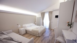 A modern hotel room with a bed, a desk, a chair, and a bedside table. - Domus Dams B&B (Montescaglioso)