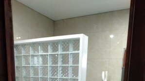 Ein Badezimmer mit Glastrennwand, Handtuchspender, Toilette und Bidet.