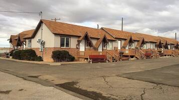 A row of motel buildings with pitched roofs and wooden balconies.