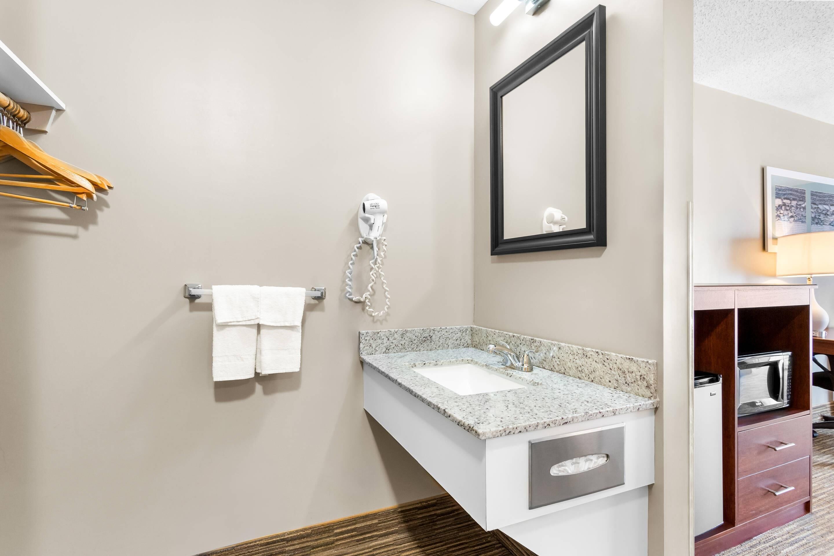 Casa de banho com lavatório, porta-toalhas e secador de cabelo.