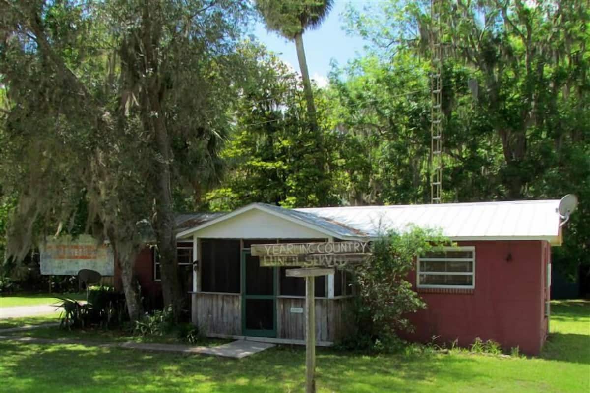 A small building with a sign that reads "YEAR IN COUNTRY LUNCH SERVED".