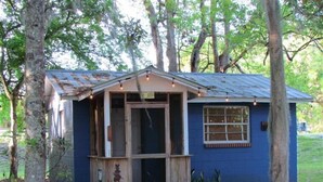 A small, single-story building with a blue exterior, a wooden door, and a window. - Yearling Restaurant and Cabins (Hawthorne)