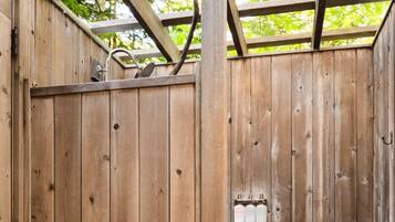 A wooden fence with a metal gate and a small electrical box attached to it.