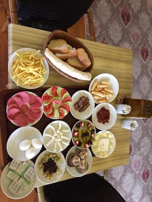 A table with various food items including bread, fries, and assorted snacks. - Cakıroğlu Villa Kent (Çaykara)