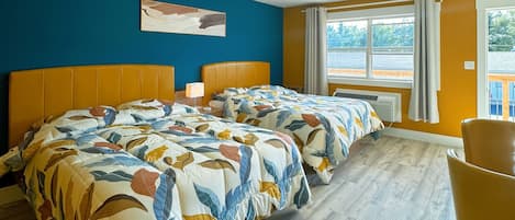 A double room with two beds, a window, and a chair.
