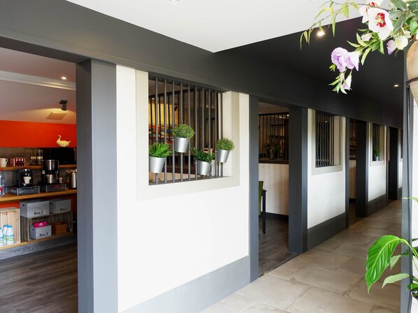 A modern interior with a kitchen area, potted plants, and a hallway. - Les Prémontrés (Falaise)