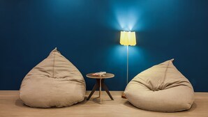 A room with two bean bags and a small round table with a lamp.