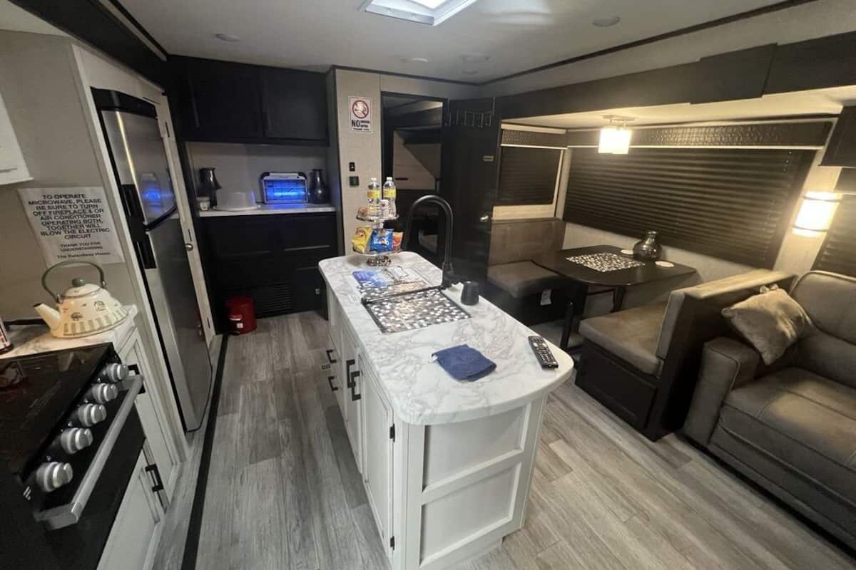 A compact kitchen with a central island, a microwave, and a sink.