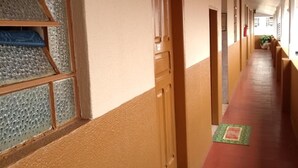 A long corridor with doors on one side and windows on the other. - Hotel Triunfo (Londrina)