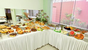 Una mesa de buffet con diversos alimentos y una planta.