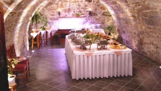 An interior with stone walls, a central table with food, and chairs around. - Landhotel Thürmchen (Schirgiswalde-Kirschau)