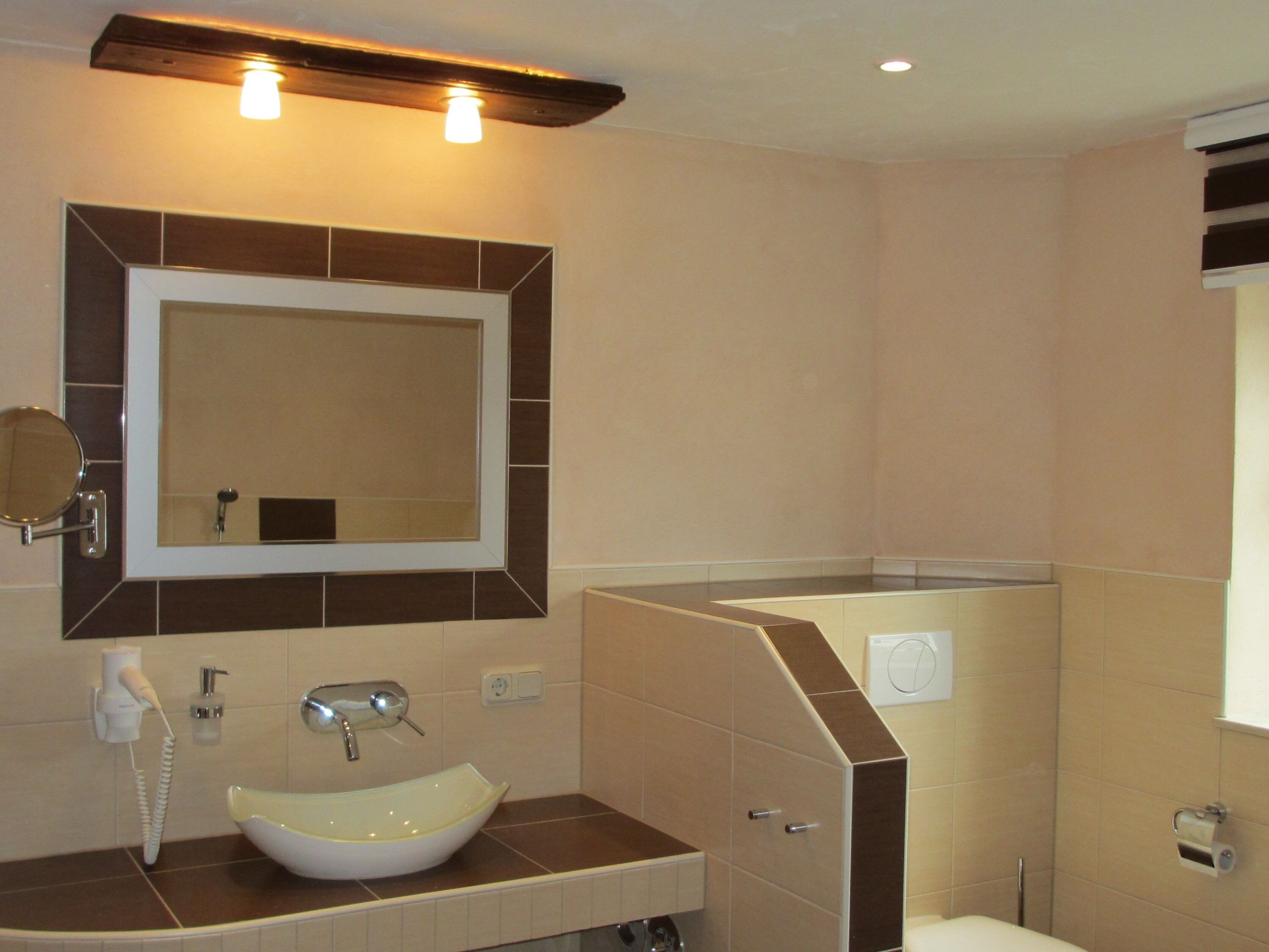 A bathroom with a white sink, a mirror, and a toilet.