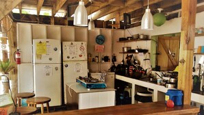 Una cocina rústica con vigas de madera, electrodomésticos blancos y una barra de madera.