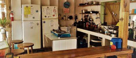 Una cucina rustica con travi in legno, elettrodomestici bianchi e un bancone in legno.