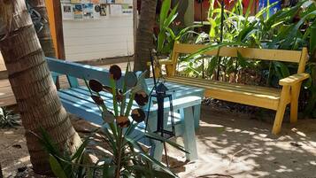 A wooden bench, a bulletin board, and a wall with a mural.
