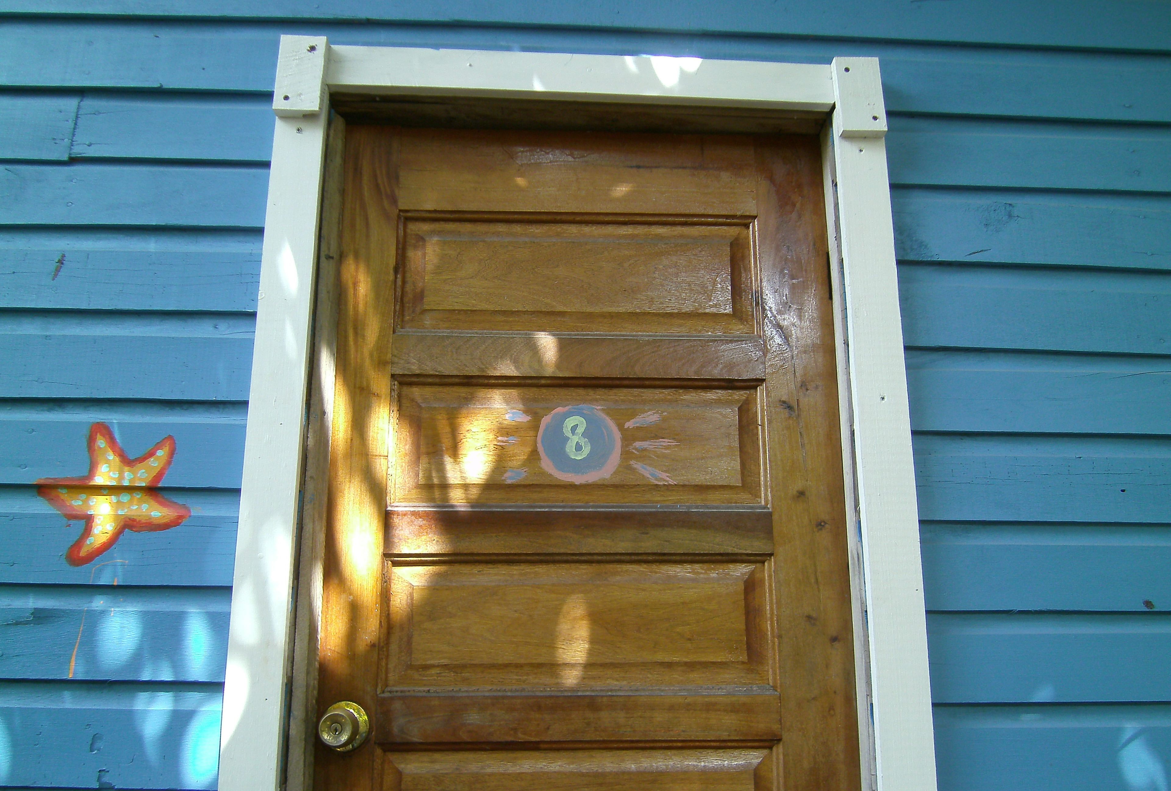 Una porta di legno con il numero 8 e una decorazione a stella sulla parete.