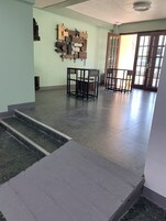 Un amplio vestíbulo con piso de mármol, una escalera y una obra de arte de madera en la pared.