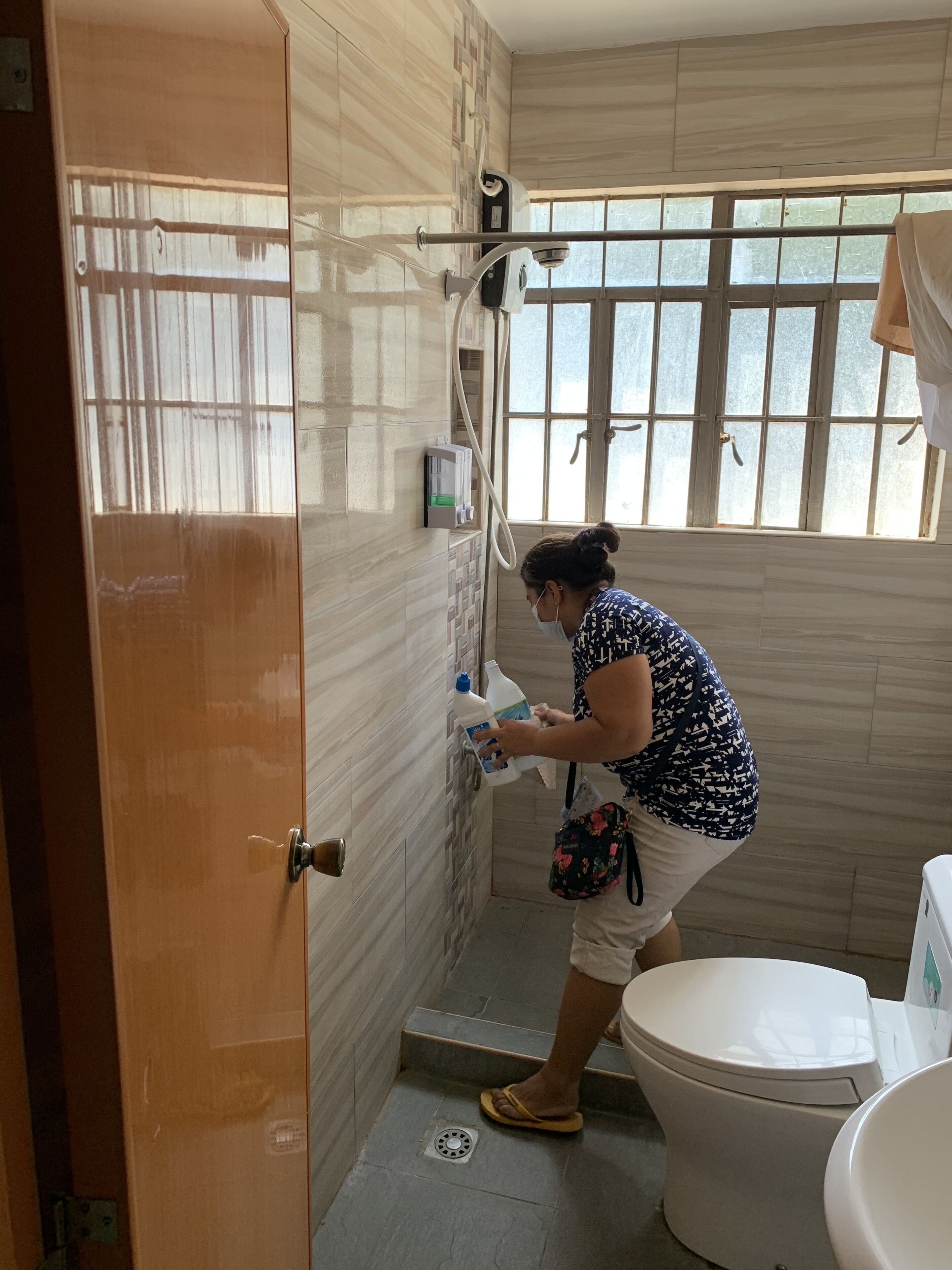 Une salle de bain avec une douche, des toilettes et une fenêtre.
