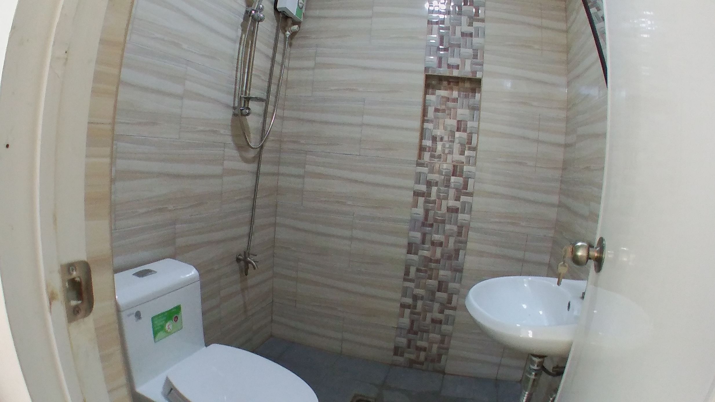 Un baño pequeño con inodoro, ducha y lavabo.