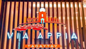 A hotel entrance with a vertical striped facade, a neon sign reading "VIA APPIA TAGAYTAY," and a stylized building illustration above the sign. - Via Appia Tagaytay (Tagaytay)