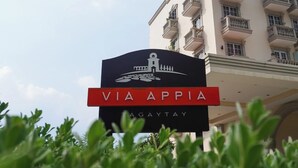A hotel sign with "VIA APPIA" and "TAGAYTAY" written on it, with a building in the background. - Via Appia Tagaytay (Tagaytay)