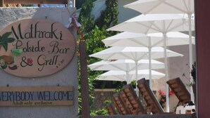 A sign for 'Mathraki Poolside Bar & Grill' with a 'Everybody Welcome' sign below it. - The Mathraki Studios Adult Only (Corfu)