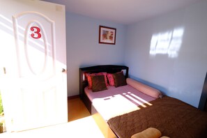 A bedroom with a bed, a door with a number, a framed picture on the wall, and a window. - Huenhimphu Resort (Phu Phan)