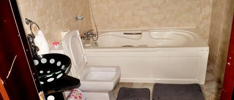 Un baño con bañera, inodoro y lavamanos.