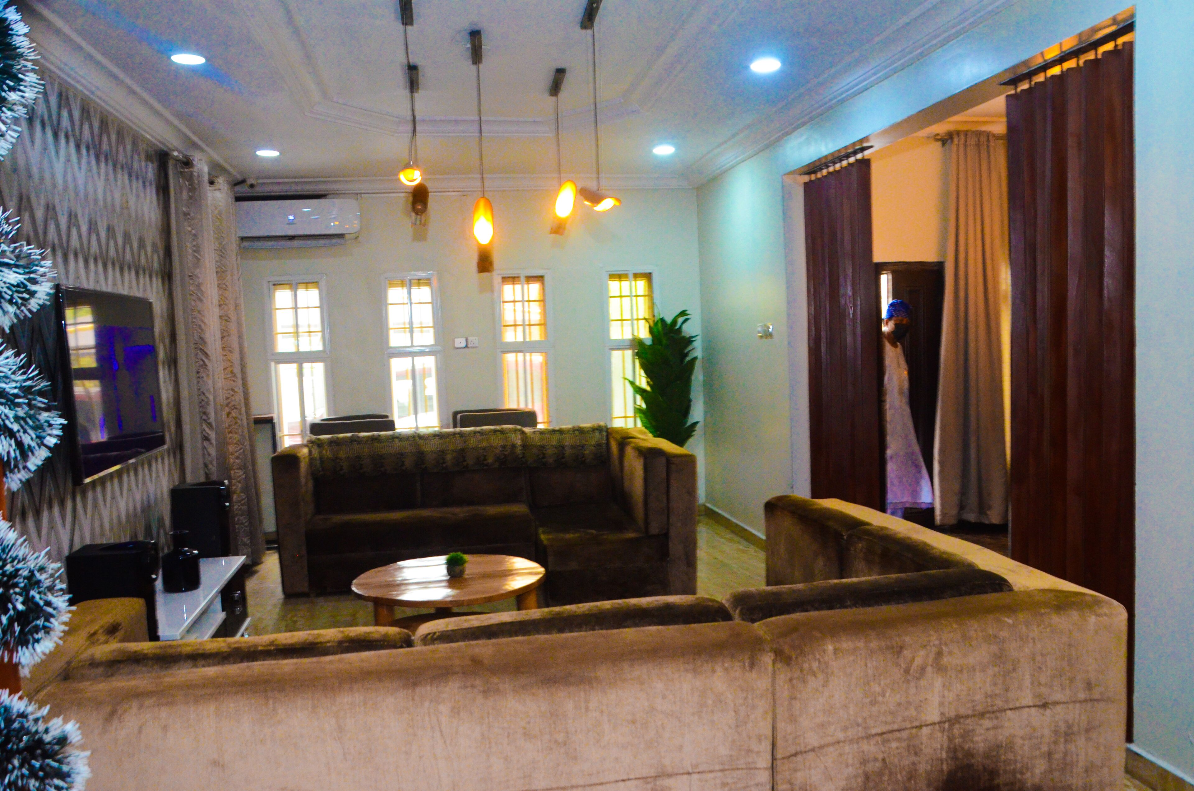 A living room with a sofa set, a coffee table, and a flat-screen TV mounted on the wall.