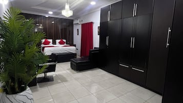 Habitación de hotel moderna con cama, armario y una planta en maceta.