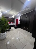 Habitación de hotel moderna con cama, armario y una planta en maceta.