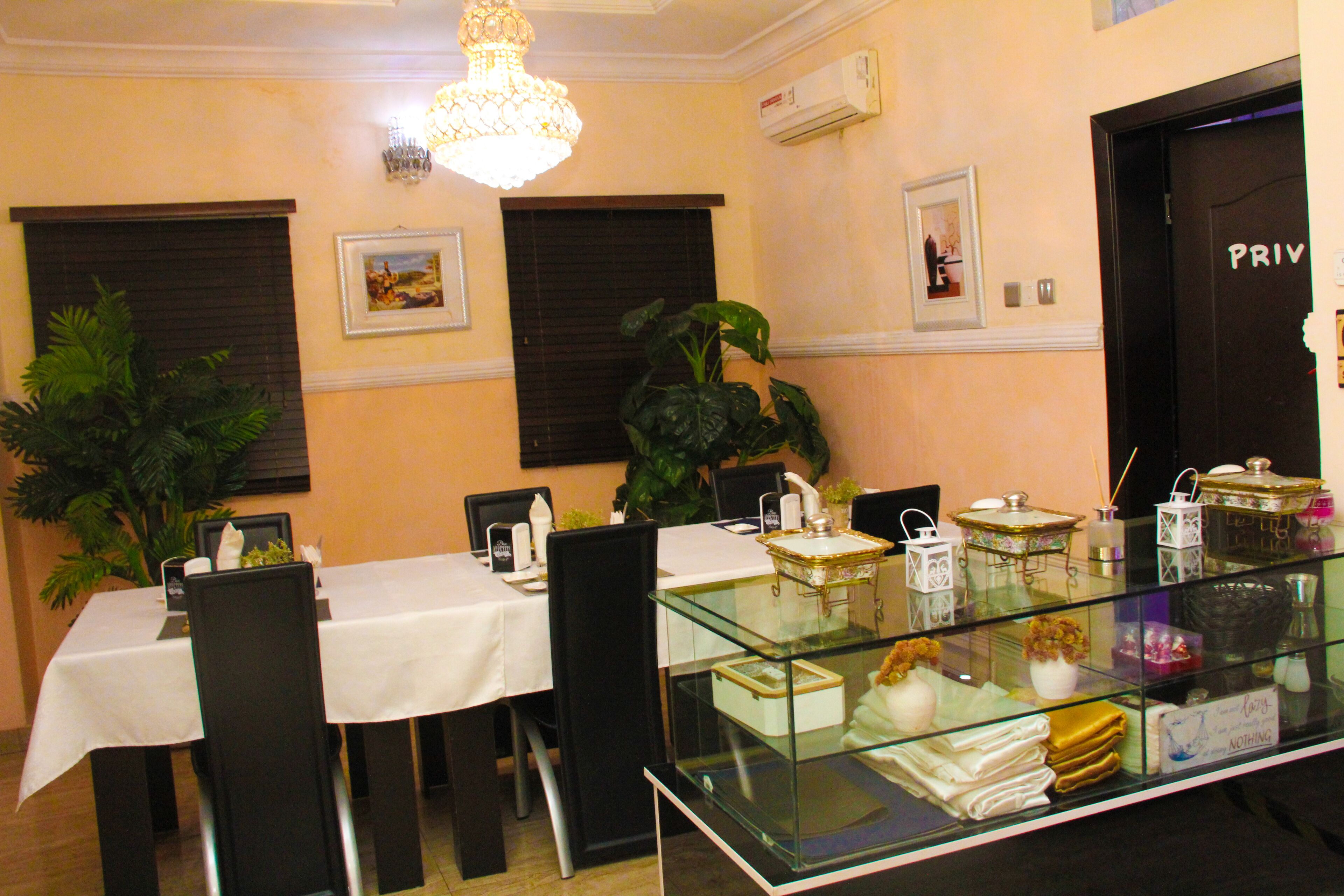 A dining area with a glass display case, a chandelier, and a 'PRIVATE' door.