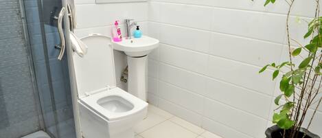 A bathroom with a toilet, sink, and shower.