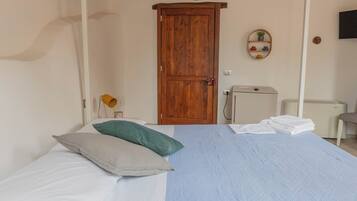 Ein Schlafzimmer mit einem Bett, einem Holzschrank, einem kleinen Schreibtisch und einer Heizung.
