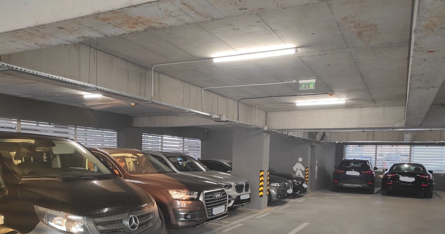 A multi-level parking garage with several cars parked in designated spaces.