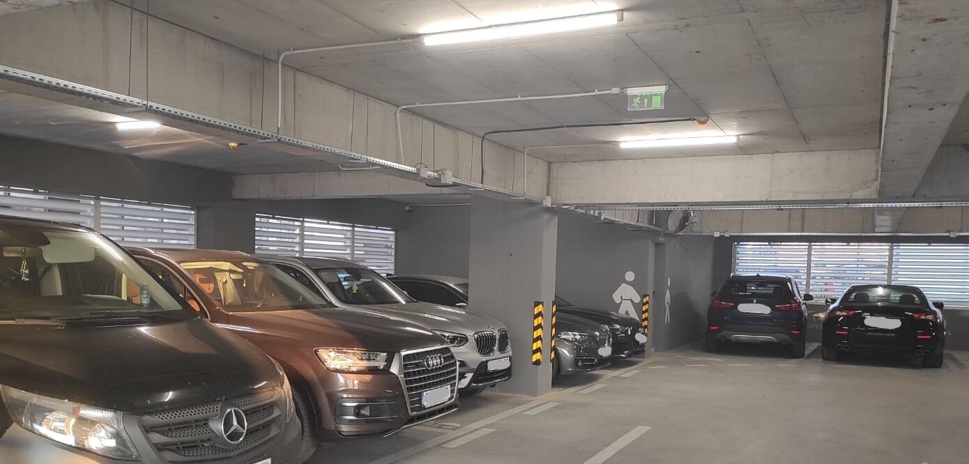 A multi-level parking garage with several cars parked in designated spaces.
