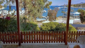 A covered outdoor area with a view of a marina and boats. - Shipwreck House (Zakynthos)