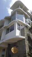 Un edificio moderno con varios balcones y ventanas amplias. Un cartel indica 'Dunn Perk Manor'.