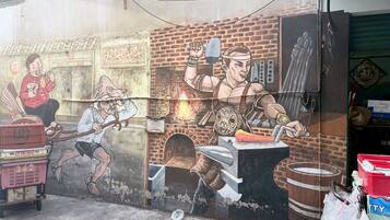 A mural with a person riding a bicycle, another person working with a hammer, and a third person holding a cup.