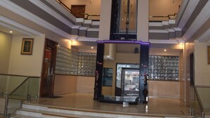 Un'imponente hall con una scalinata centrale, una reception e una parete decorativa.