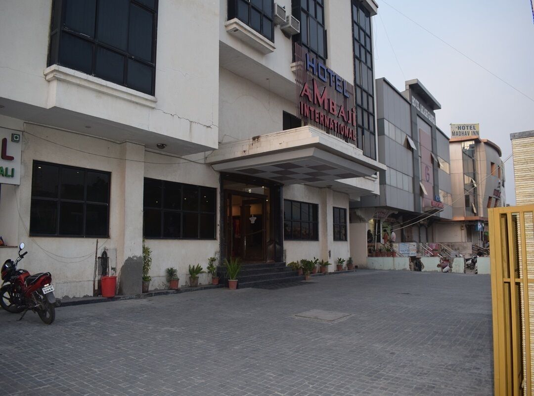 A hotel with a prominent entrance, potted plants, and a clear view of the entrance area.