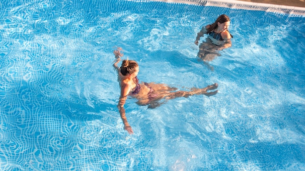 A swimming pool with clear blue water and a tiled edge. - Domki Agat (Sarbinowo)