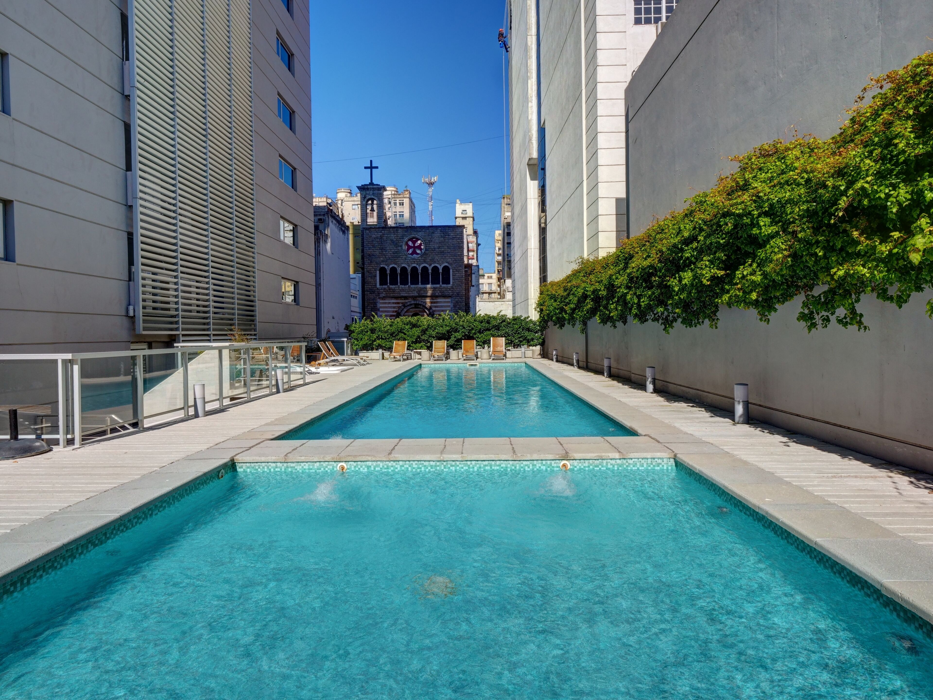 Una piscina al aire libre, sillones reclinables de piscina