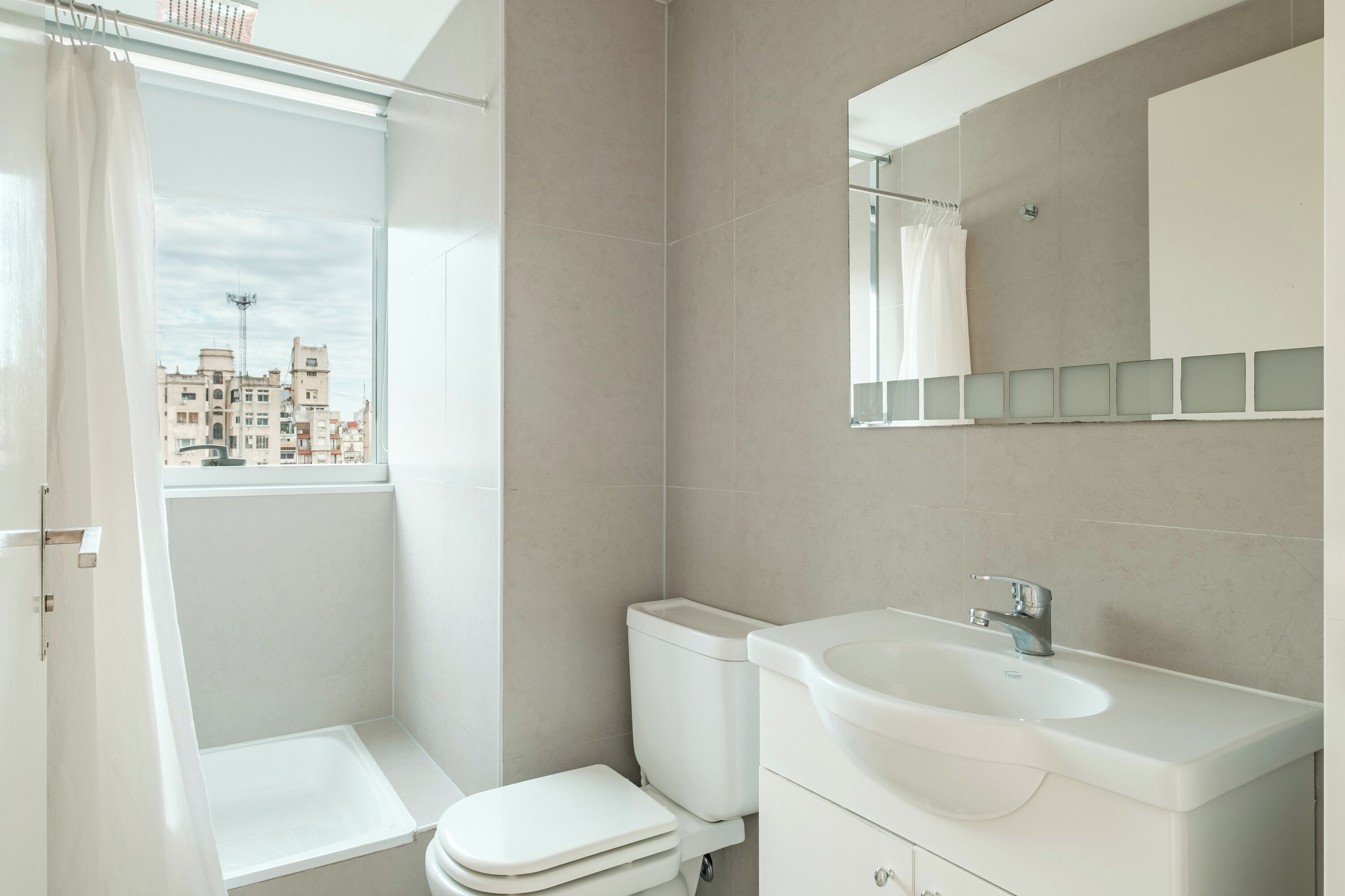 A modern bathroom with a toilet, sink, and shower.