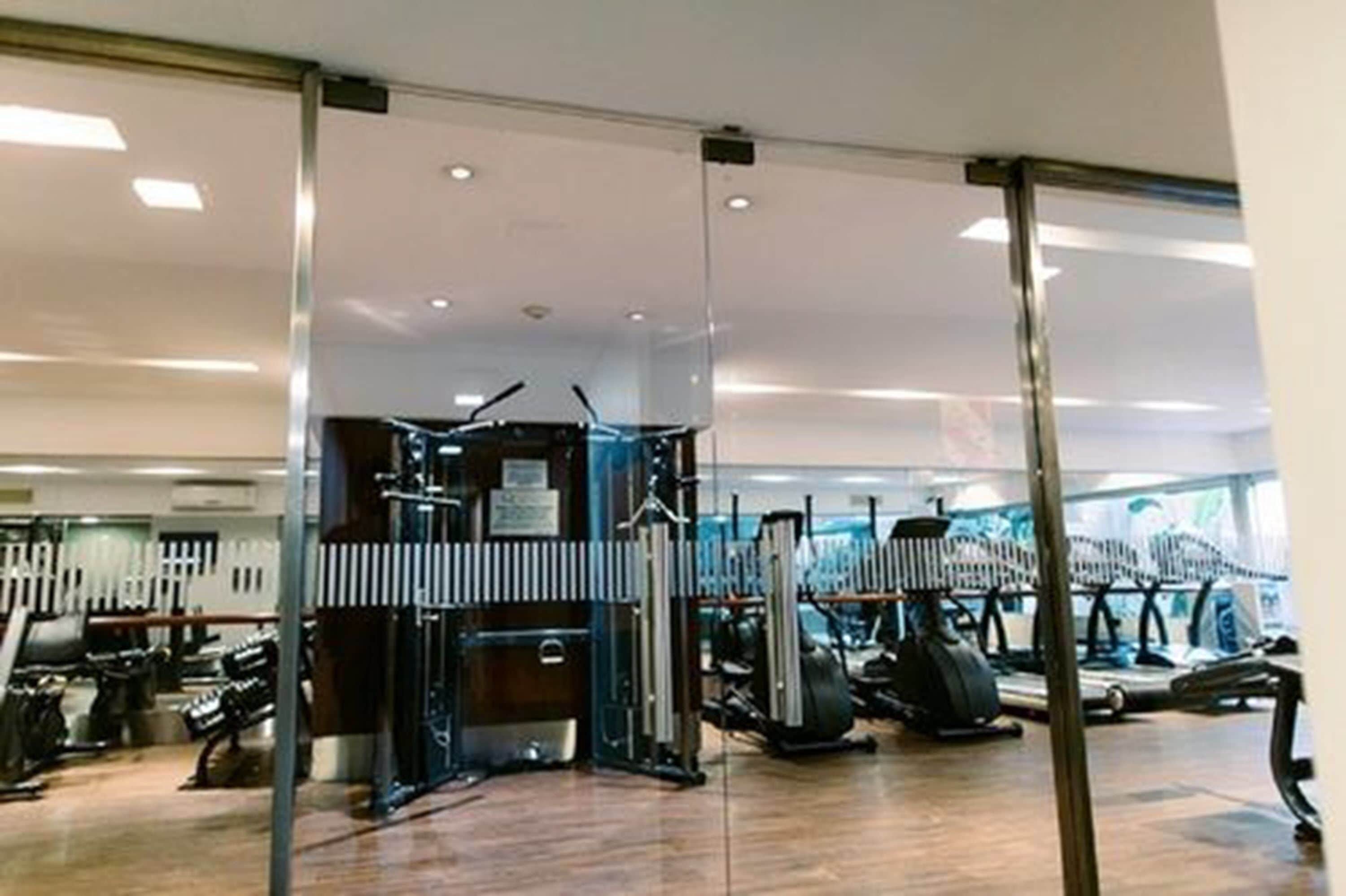 Une salle de sport équipée de divers appareils d’exercice, notamment des tapis de course et des appareils de musculation.
