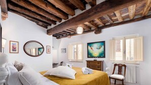 A bedroom with a bed, a dresser, a chair, a mirror, and a painting on the wall. - AlbergoDiffusoVolterra (Volterra)