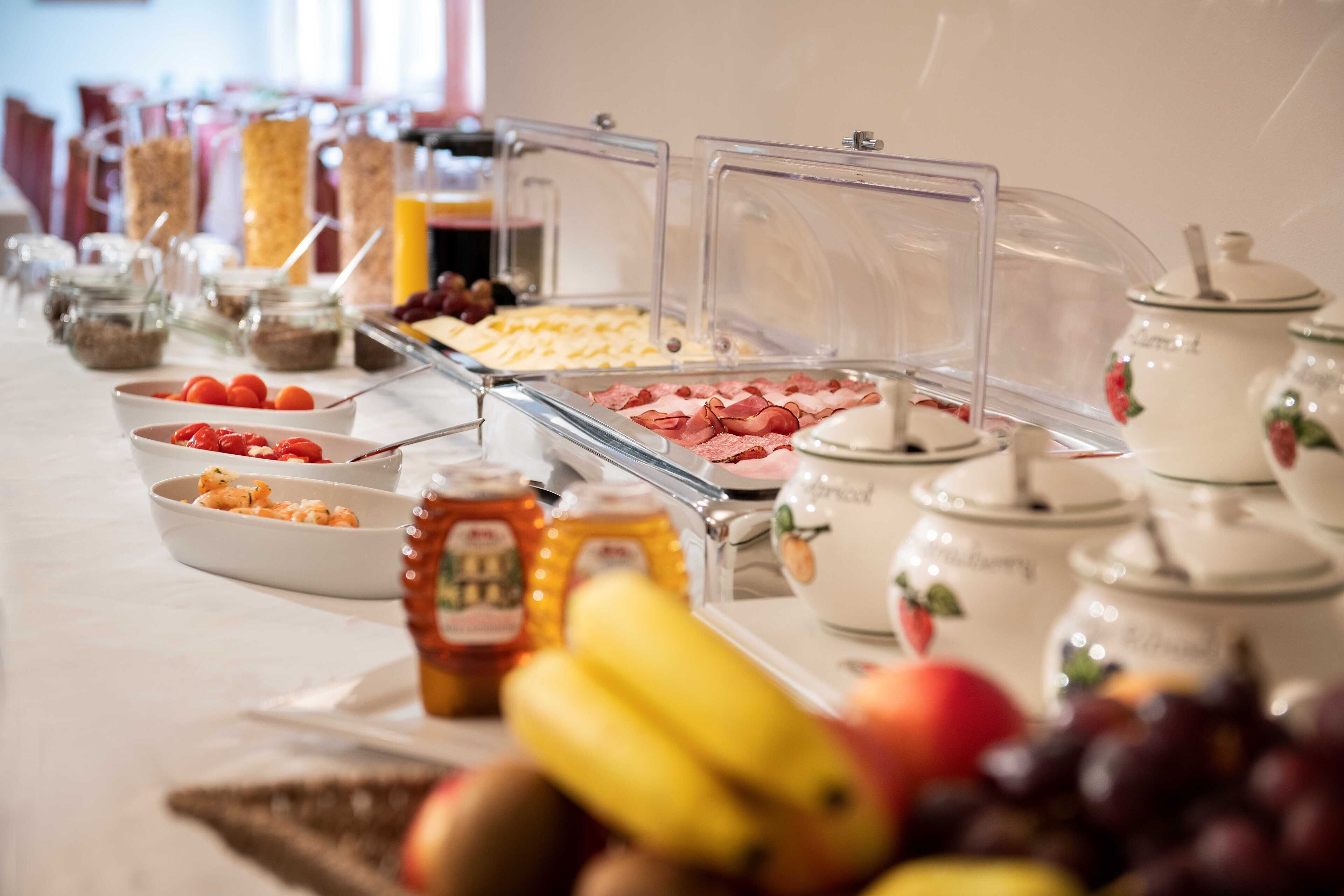 A buffet with various food items and condiments.